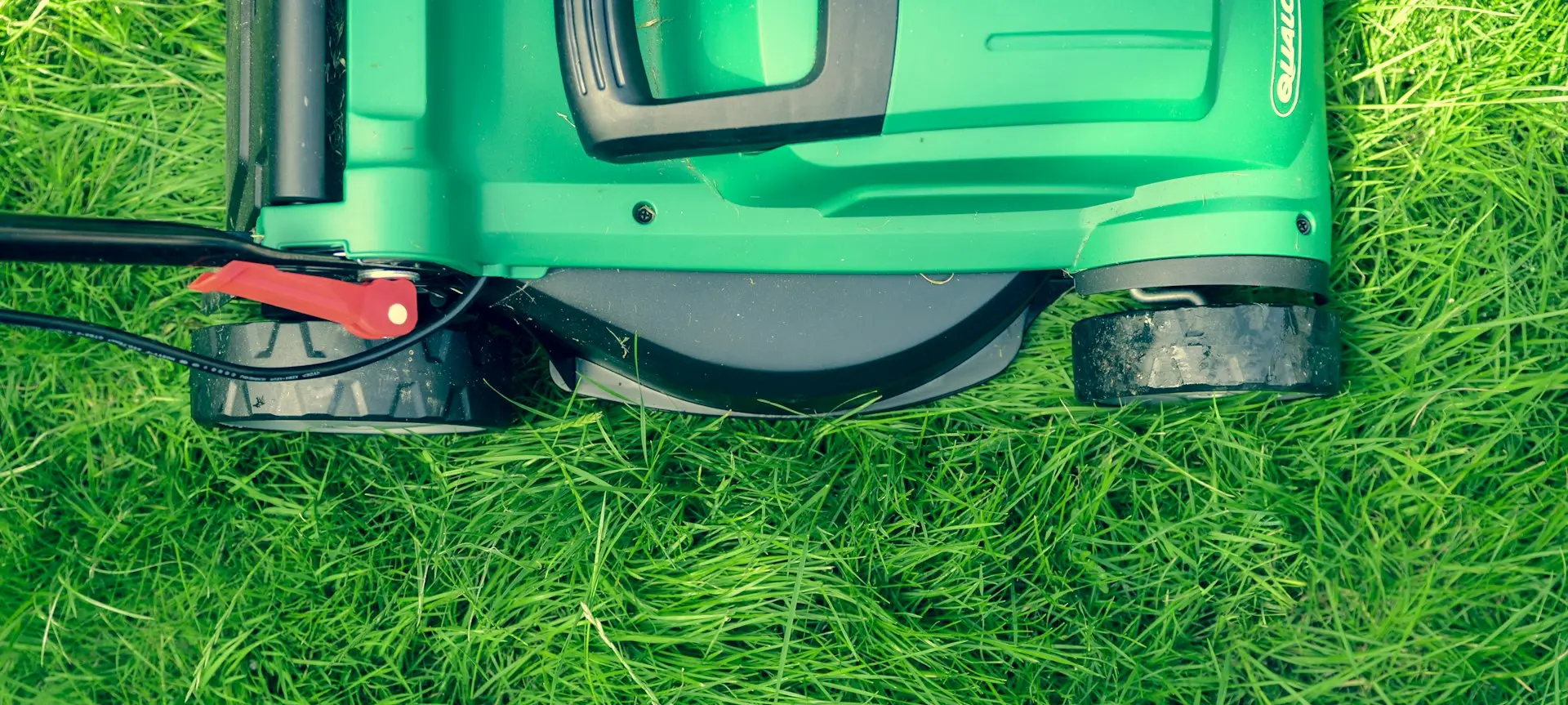 green and black lawnmower on green grass